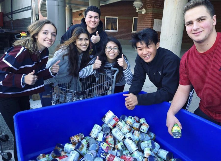 Students prepare to load donated cans onto a Manna Food Center truck. 