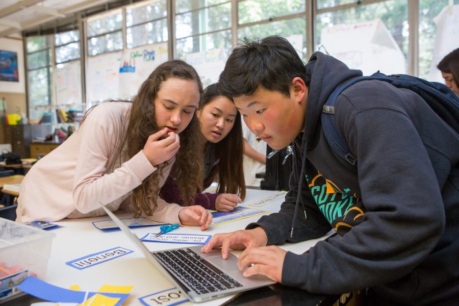 Three students collaborate during science class.