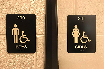 The boy and girl bathroom signs at RM are shown side-by-side.