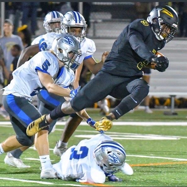 Ayoola dives over four Clarksburg defense as he carries the ball upfield.