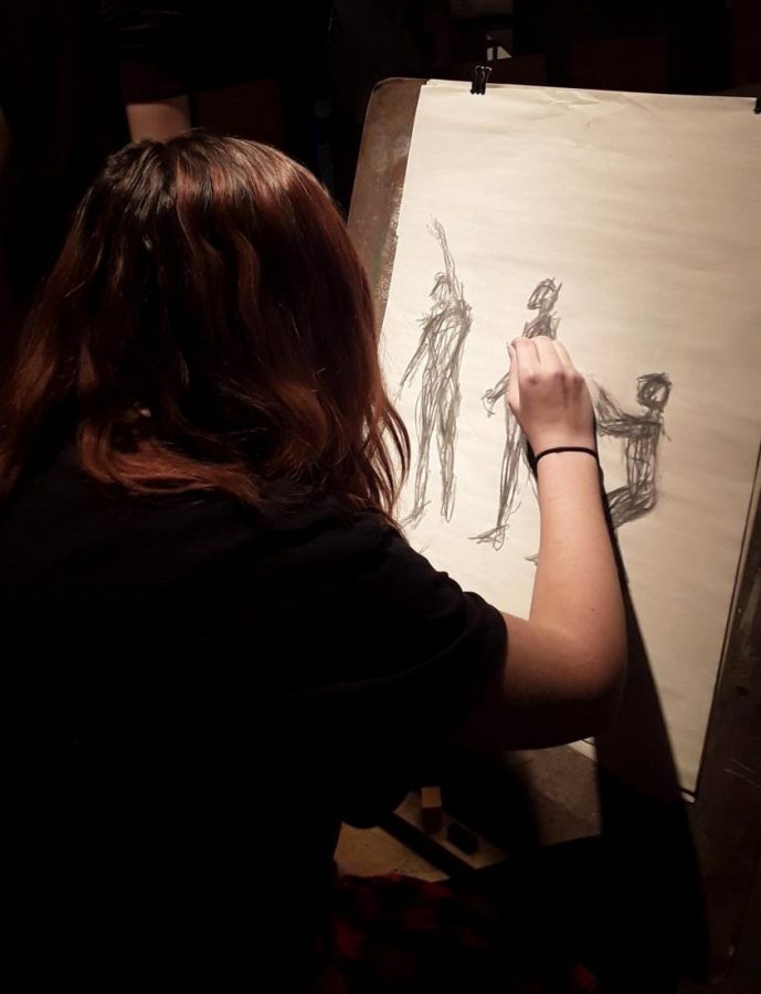A student completes a live figure study in the AP/IB Art class.