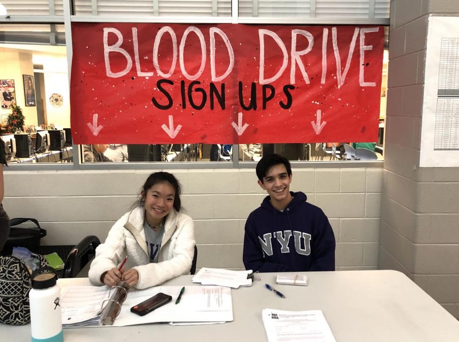 Juniors Kaia Lee-Espiritu and Anand Chitnis pose for a photo at the SGAs blood drive sign up stand. The blood drive, which will take place on Feb. 19, is accepting blood from students 16 years and older as part of an annual initiative with Inova Blood Donor Services.