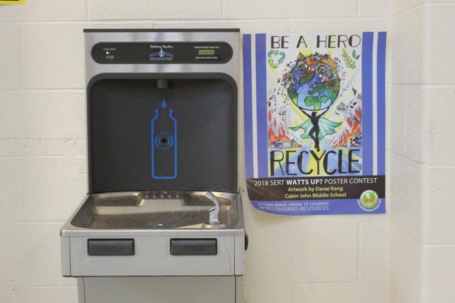 A SERT poster next to an RM water fountain encourages students to maintain green habits. 