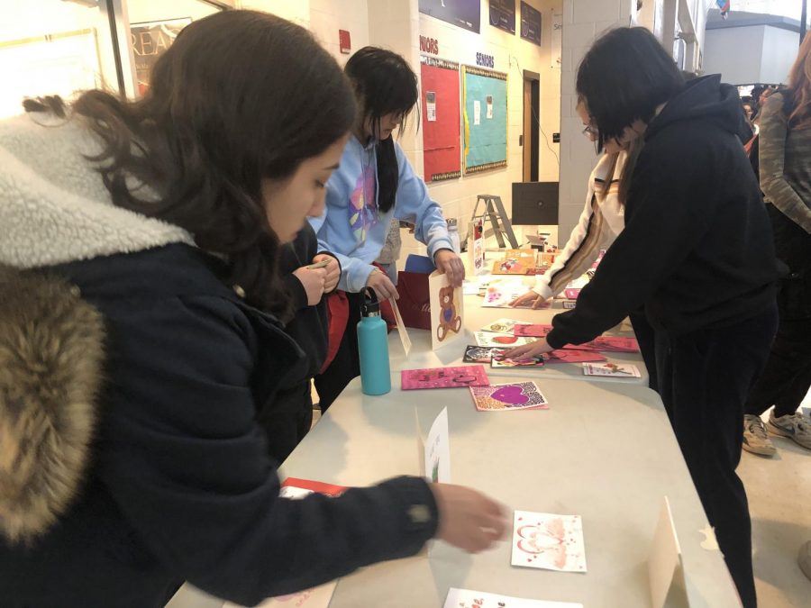 Seniors Ashley Guevara and Gabriella Ceniza prepare for the annual Valentines Day card sale on Main Street, hosted by National Art Honor Society (NAHS). Various members of NAHS will be selling these cards during lunch throughout the week of Feb. 10 to Feb. 15 in order to raise money for their organization.