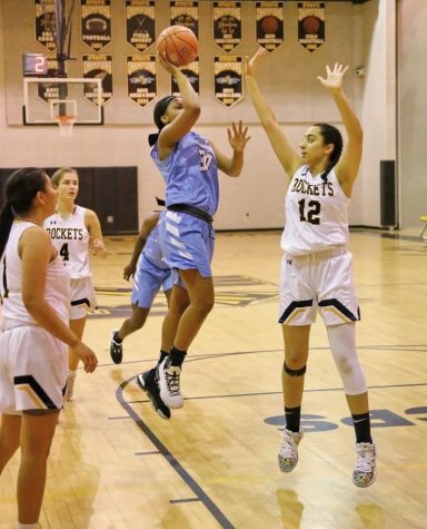 Senior varsity girls basketball player, Talia Kouncar works with fellow teammates to block a layup and gain possession of the ball.