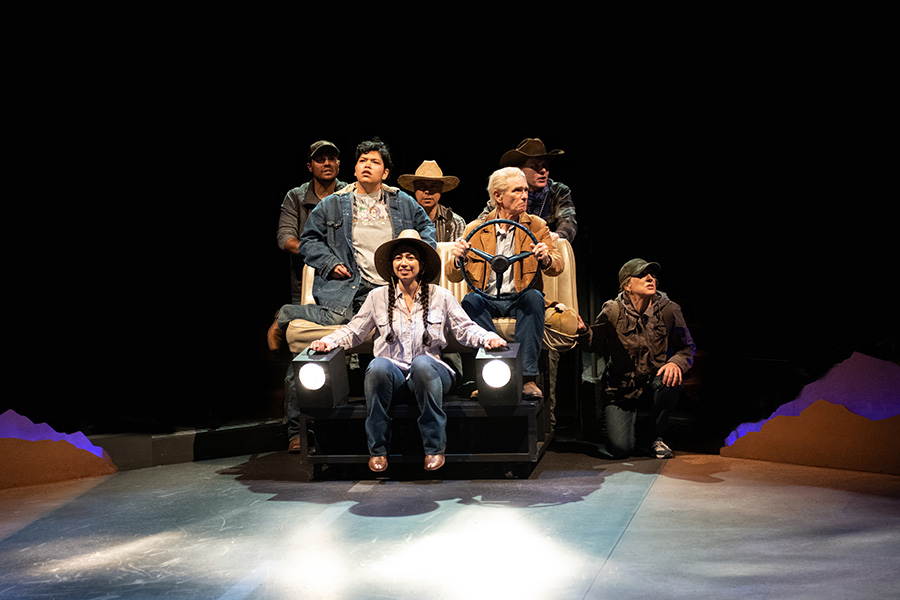 The cast of Mother Road journey together in a cramped car on stage.