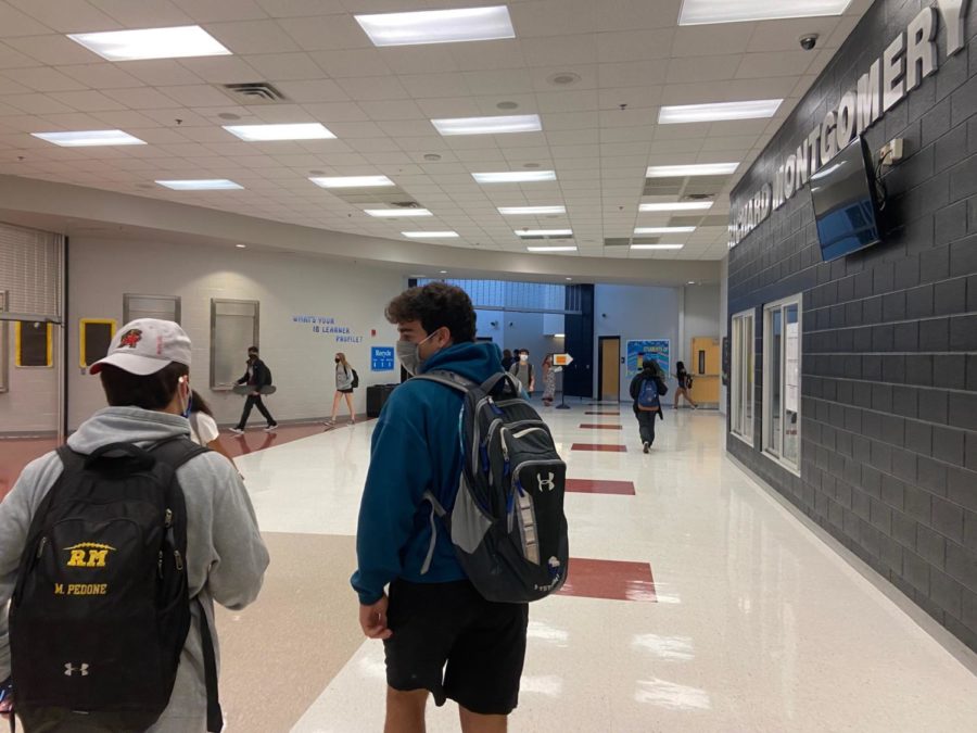 Students walk through a school hallway between class periods.