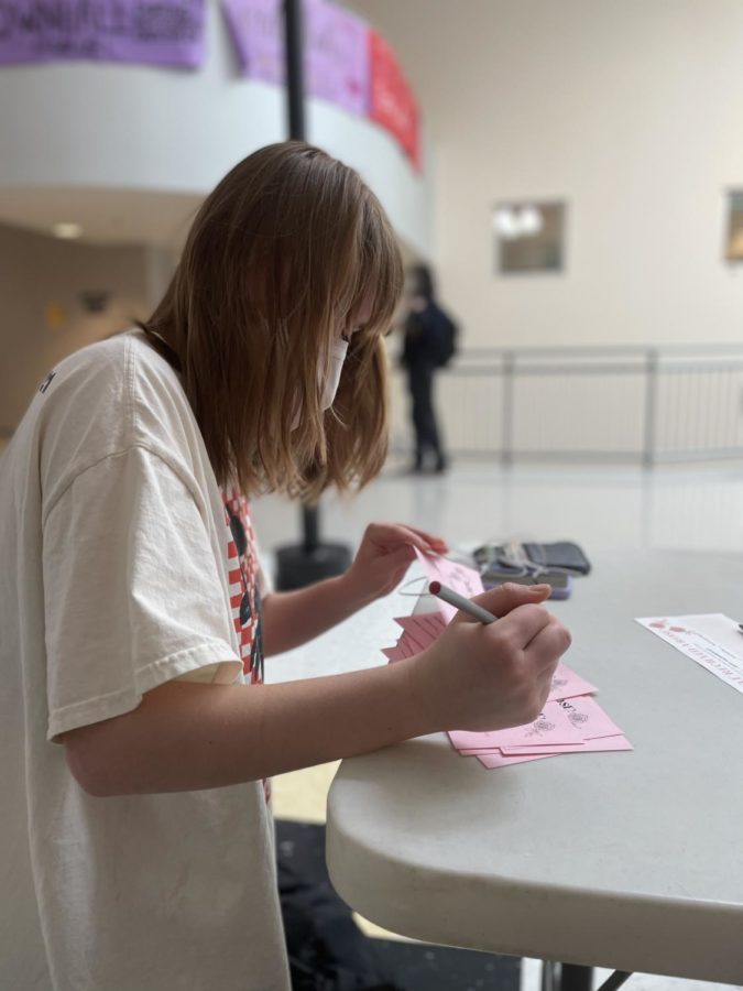 Senior Hope Hetrick fills out a card to accompany the roses she purchased for her friends. On Main Street, Fine Lines sells roses to be delivered to student’s first periods on Valentine’s Day. “Giving each other roses is me and my friends favorite tradition. We’ve been doing it since freshman year. Hetrick said