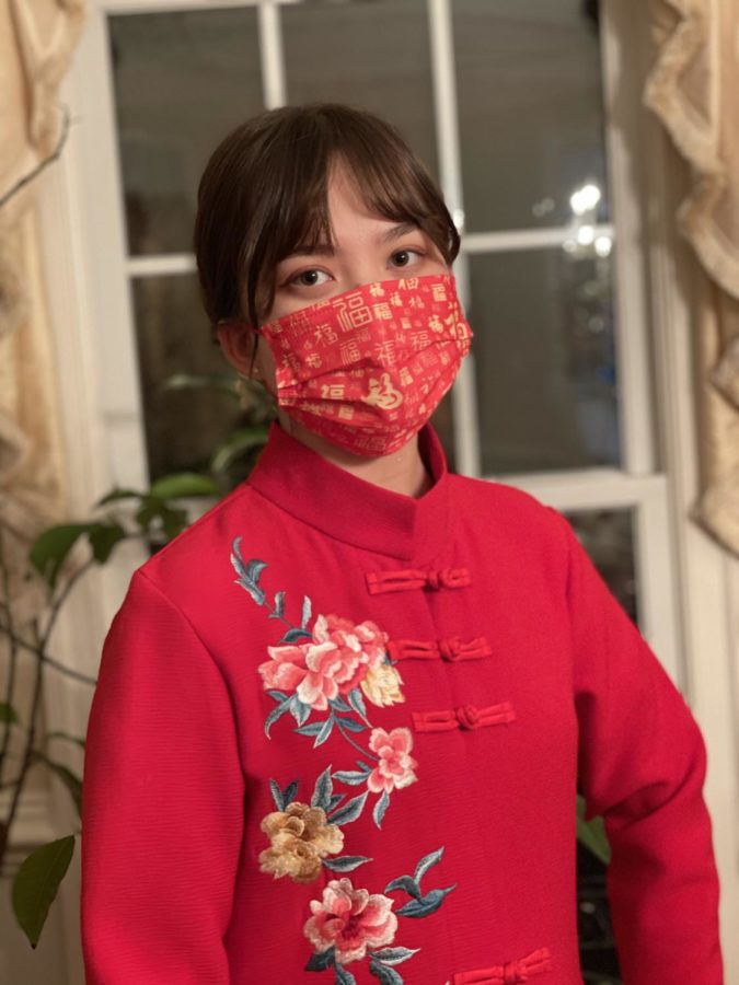 Senior Angelina Guhl wears an adapted form of qipao, a common Chinese dress style, with a mask decorated with the character for 