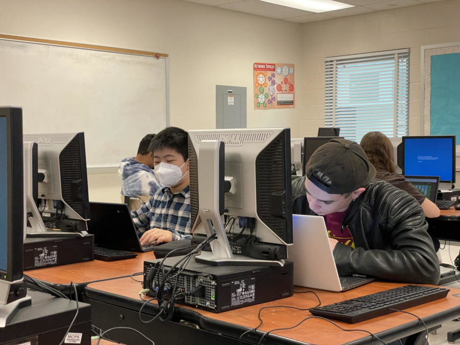 Freshman Kevin Si and sophomore Adin Bokman work on their laptops. Following MCPS' new policy, RM classrooms have featured a mix of masked and unmasked faces.