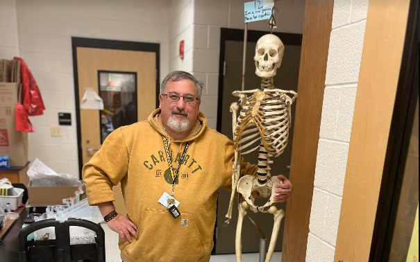 Dr. Kovacs poses beside a real skeleton.