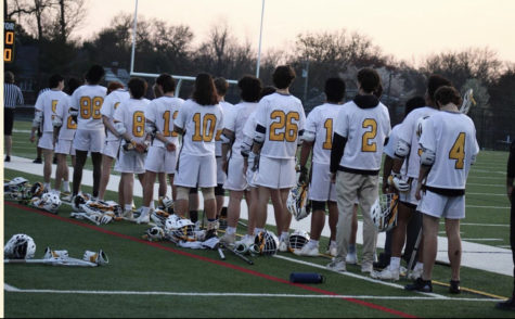 Boys varsity lacrosse team lines up during the national anthem. 