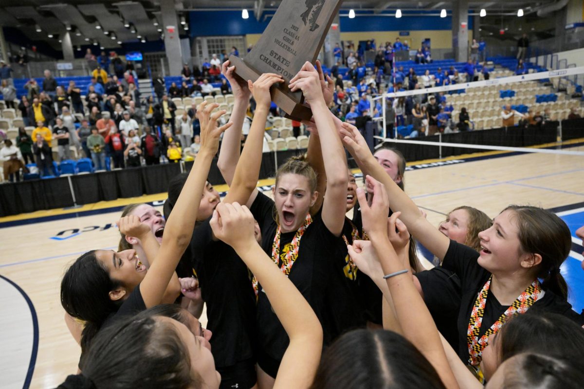 Junior middle blocker Caroline Kaye raises the state championship trophy after the Rockets defeated the Leonardtown Raiders 3-1 to win their first title in school history. 