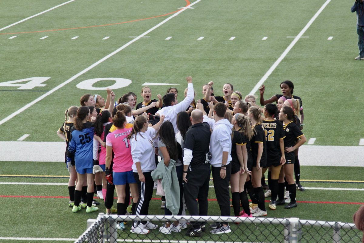 Girls Varsity soccer stands in a huddle preparing for the second half of the regional championship. 