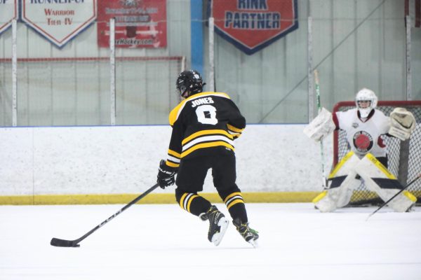 Sophomore Ryan Jones looks to shoot the puck with space in front of the net.