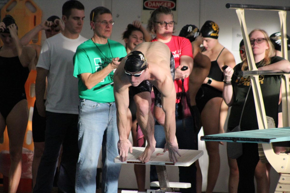 Senior Nico Schultz jumps off the starting blocks during a RM swim dual meet. 