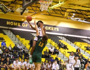 Senior Tavares "Boogie" Vaughan-Cooper elevates over a defender at a home basketball game.