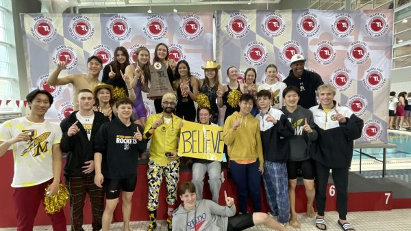 The swim team celebrates together after securing the state championship title.