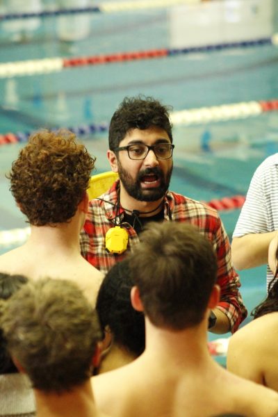 RM swim and dive head coach Mr. Akshay Gandhi stares into his swimmers before they compete at the regional championship. 
