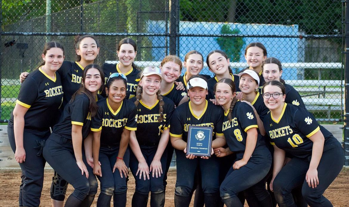 The varsity softball team poses for a picutre with the regional championship plaque following their win on May 16.