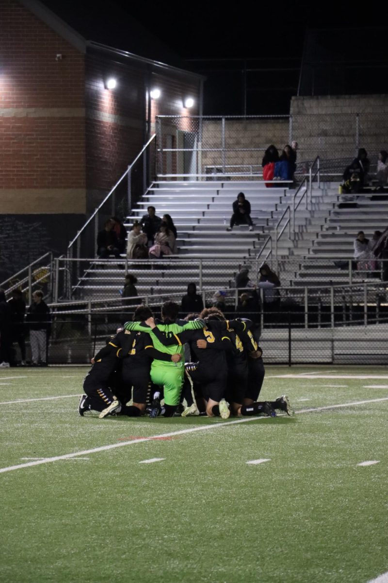 The boys varstiy soccer team huddles during an important game. 