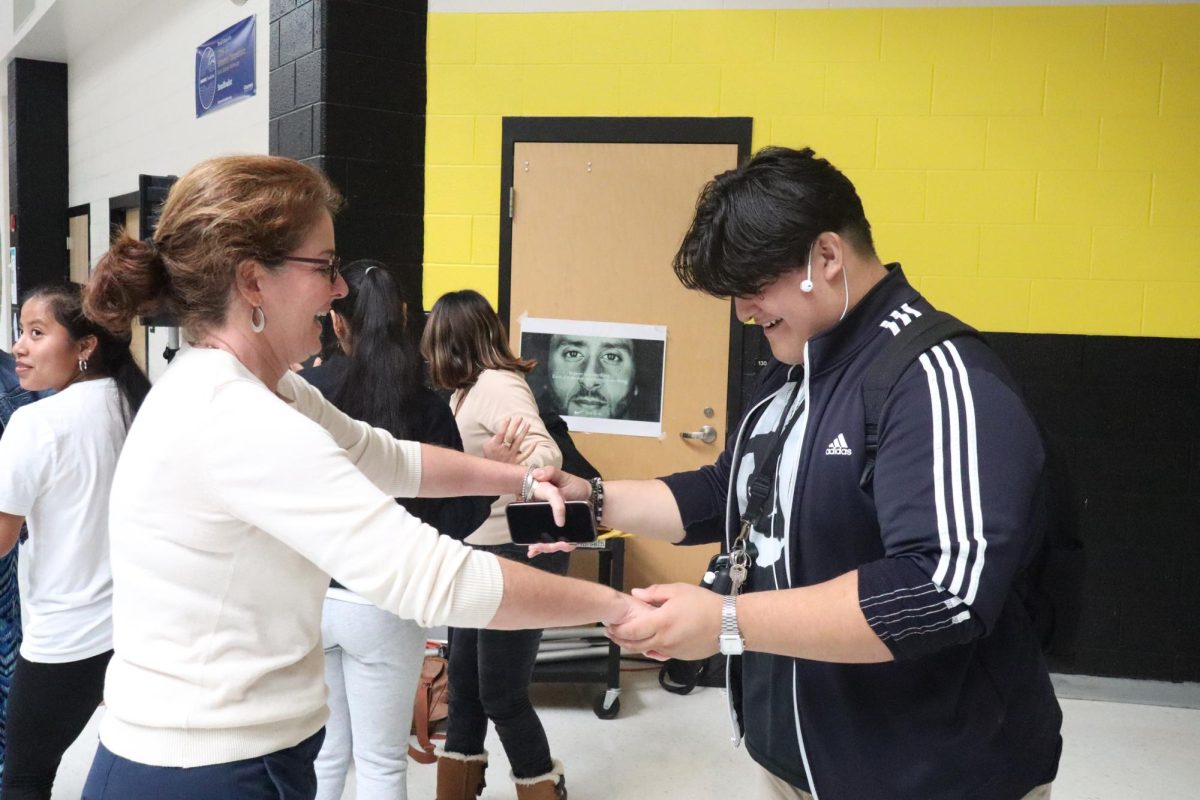 Principal Alicia Deeny dances with a student on Main Street to celebrate Hispanic Heritage Month.