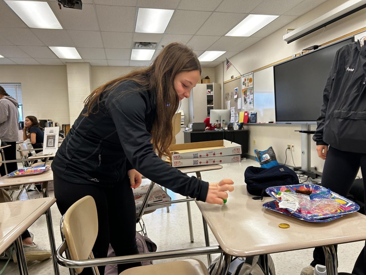 Junior Callie Guttman spins the dreidel at the Jewish Student Union monthly meeting. This month, the meeting led by junior Izzy Triandafilou was dedicated to celebrating Hanukkah. The club meets to discuss events in the Jewish community, Jewish heredity, and celebrate holidays."I love having a room to be together with other Jewish kids at the school," Guttman said.