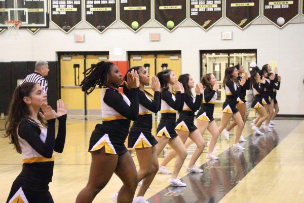 Winter cheer performs at a basketball game. 