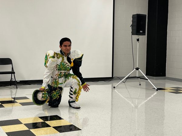 Senior Luis Pizo kneels during his traditional Bolivian dance performance. 