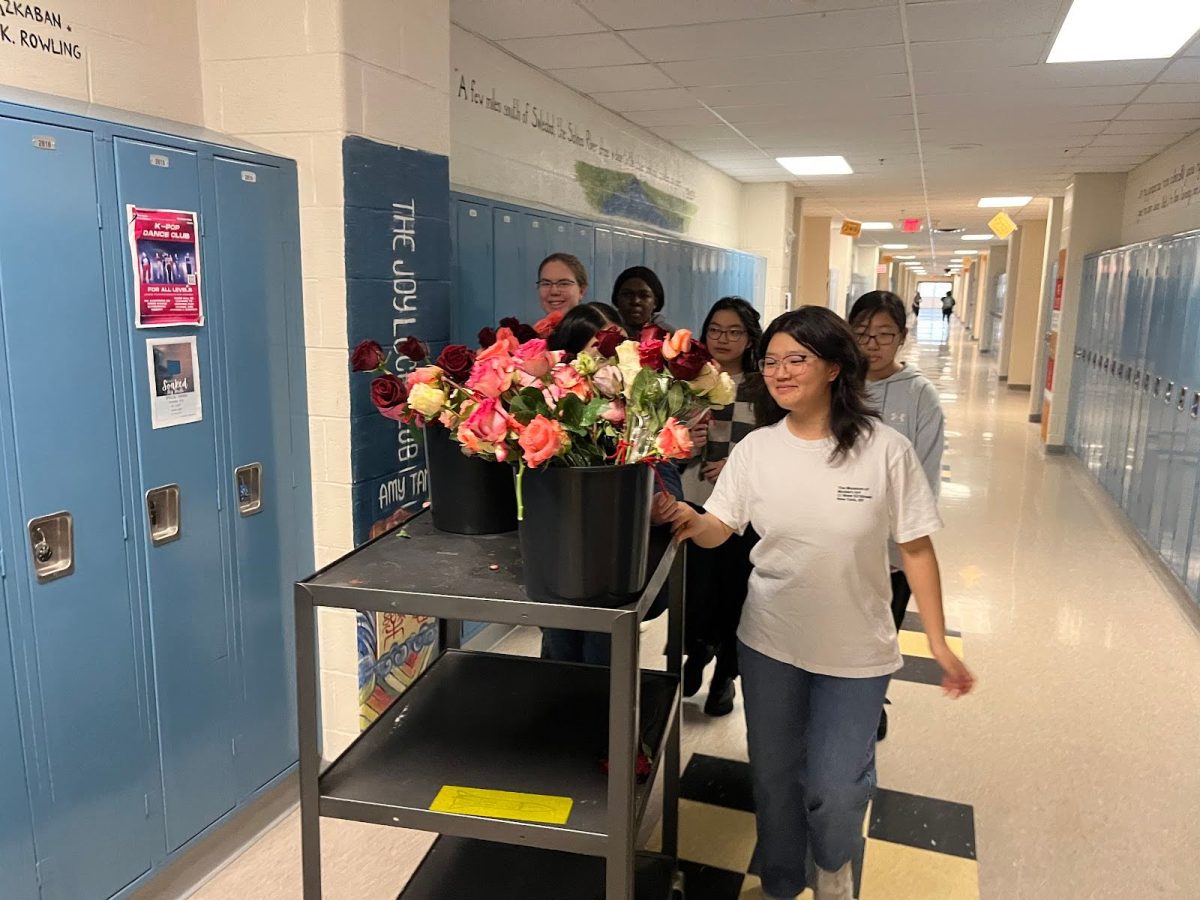 Junior Kimberly Lee pushes a cart with roses and notes to be delivered to students’ first periods Friday, Feb. 14. 
