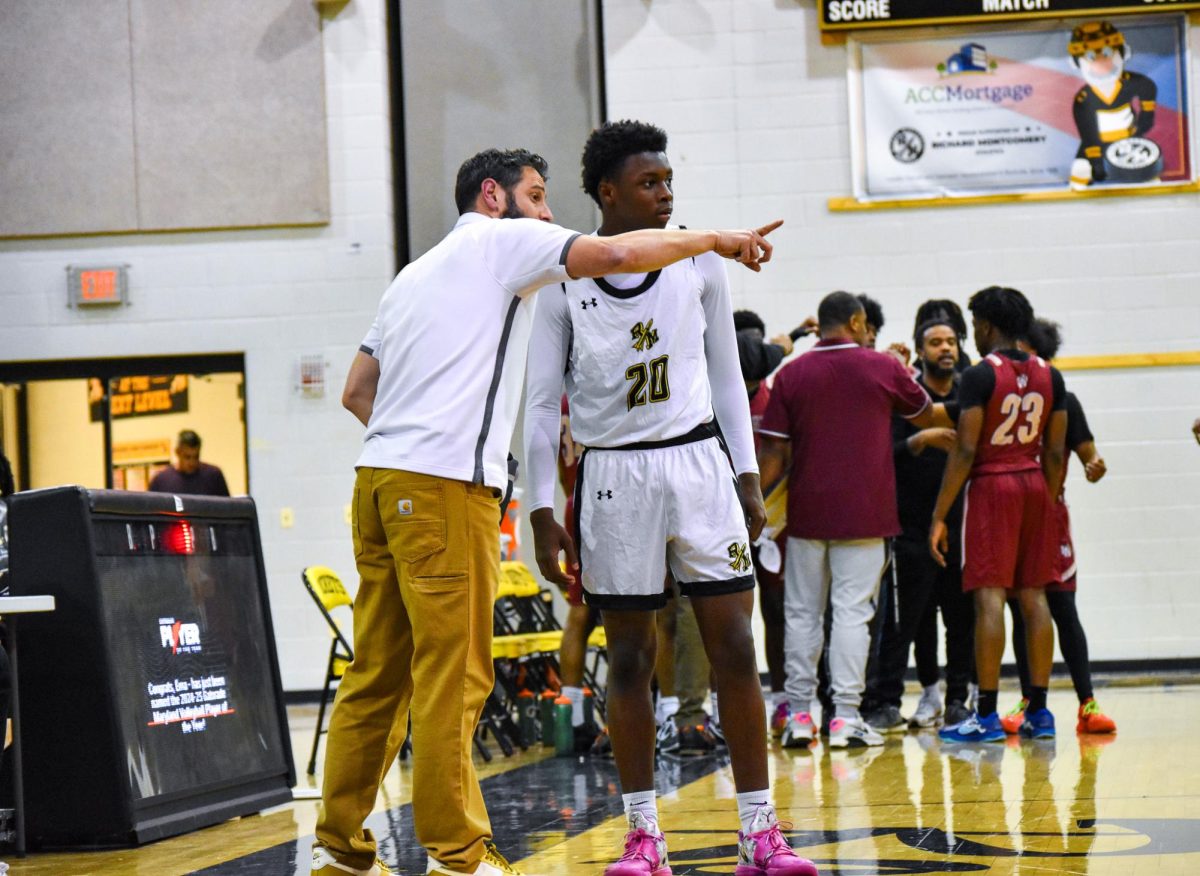 Varsity boy head coach David Breslaw guides one of his players after a late timeout in the game.