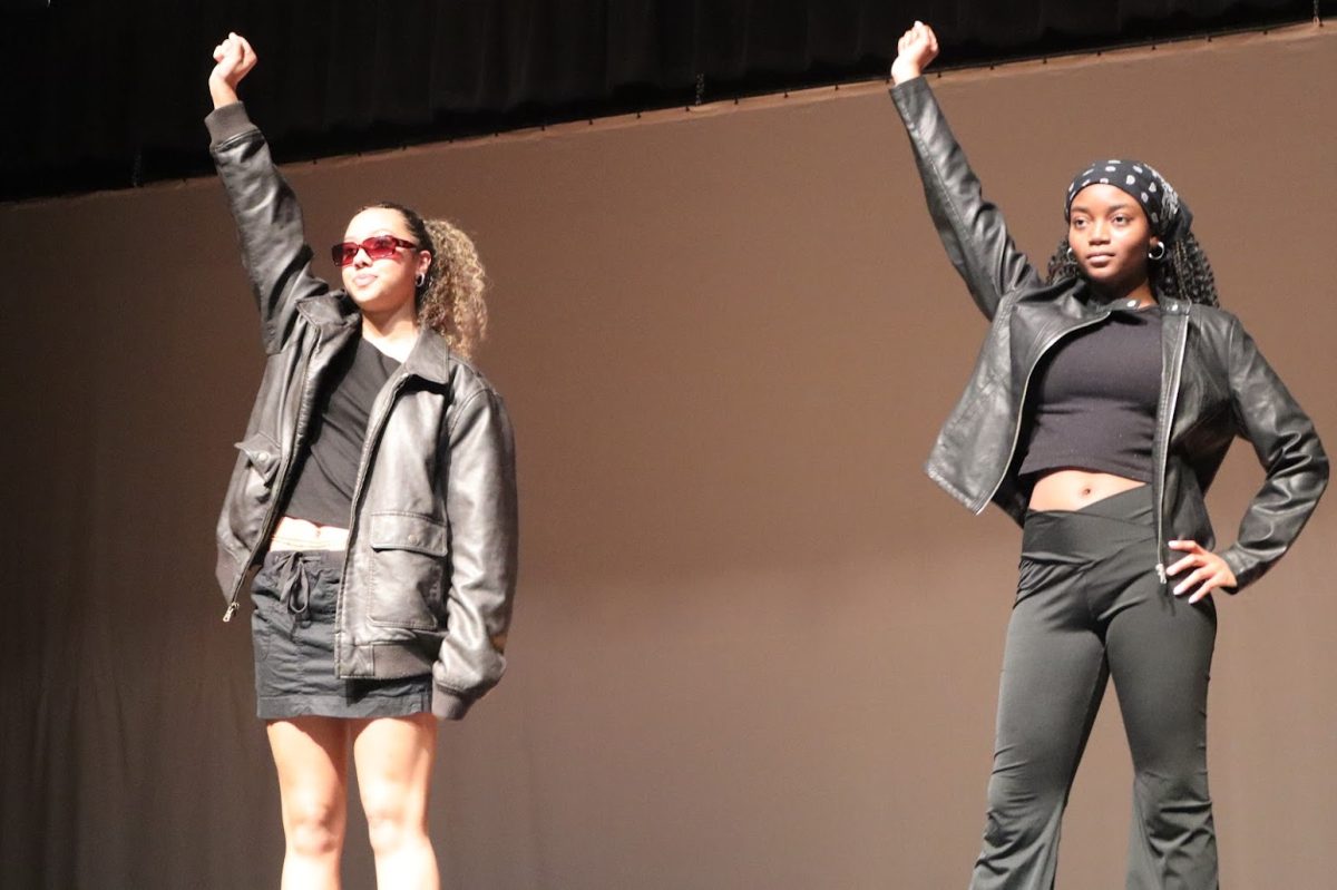 Senior Corinne Howard and senior Madison Carter raise their fists in celebration of their African American identity
