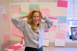 Ms. Goetz wears the crown given to the yearly “Speed Trig Queen” in front of the wall of students’ perfect scores. 