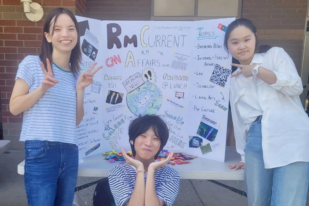 Sophomores Emilie Koo, Lucas Han and Angie Wu, co-founders of the RM Current Affairs Club, pose in front of their trifold at the club fair. (Photo courtesy of Emilie Koo)