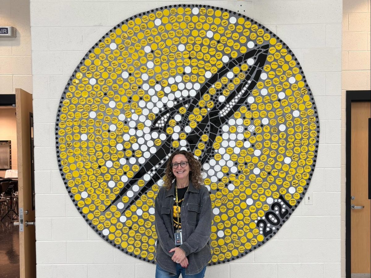 Speech pathologist Sheryl Stevens stands against the Rocket symbol on Main Street 