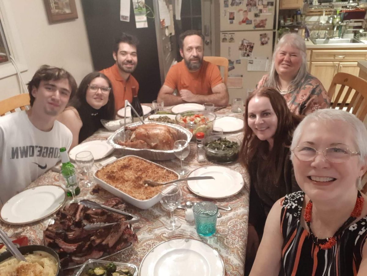 Gjoni, her mother (far right corner) and other family members gather around the dinner table to celebrate Thanksgiving together. Their meal consists of many different Bulgarian dishes, mixed with common Thanksgiving foods in America. (Photo courtesy of Mariya Hristova)