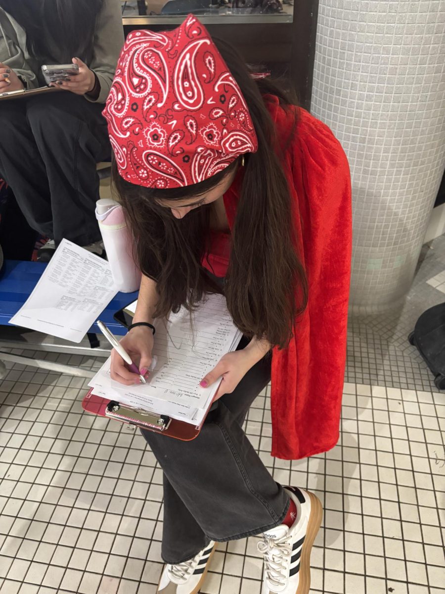 Junior Adriana Benavides records relay times at swim meet. (Photo Courtesy of Norah Sonti)