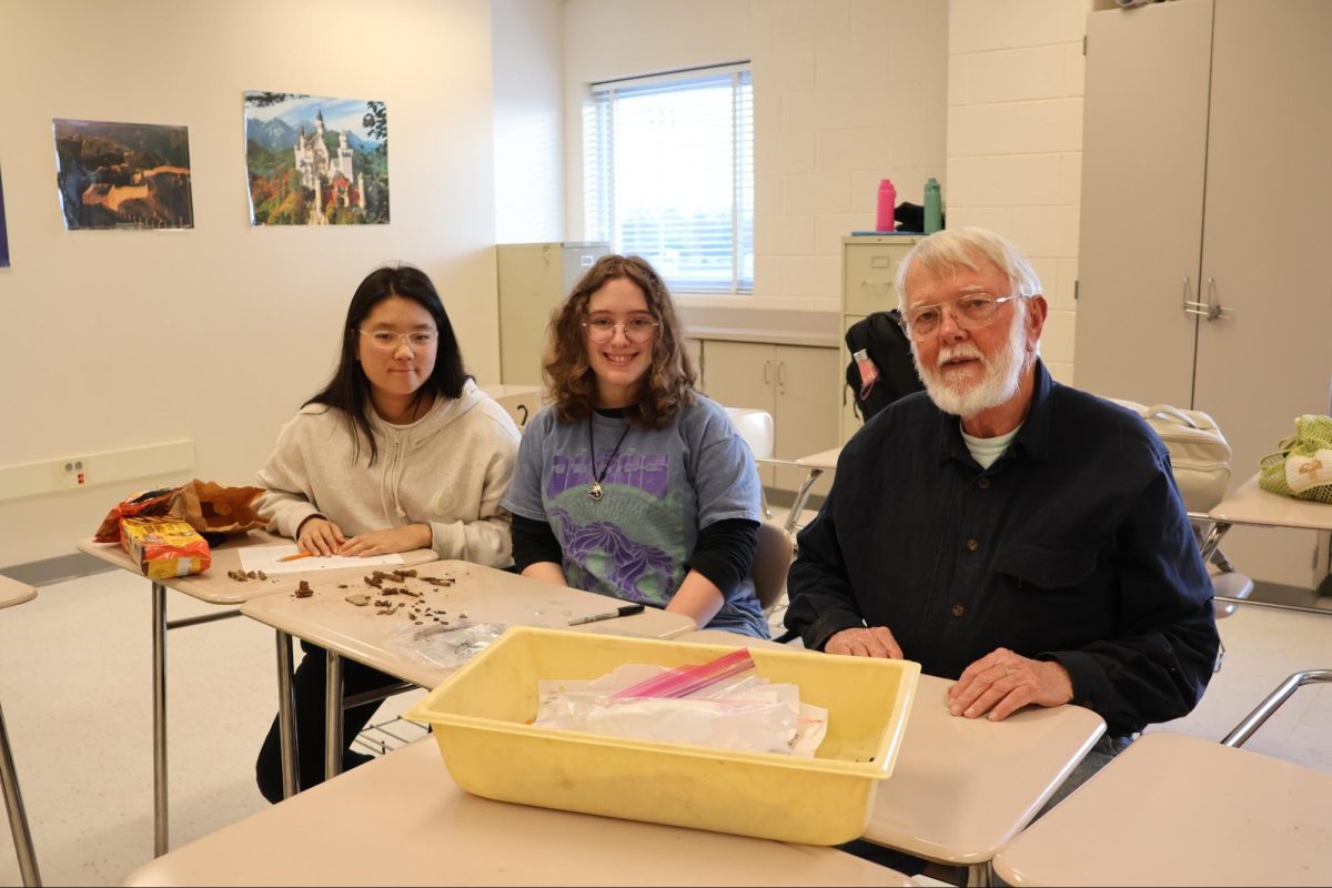 Sophomores and Archeology Club members Kate Cho and Orly Echerman sit with former social studies department head and Archeology Club founder Robert Hines during a club meeting afterschool.