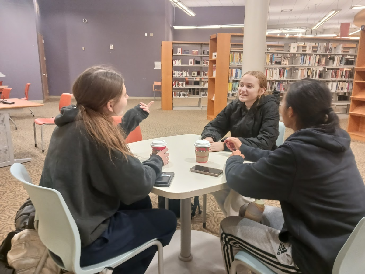 Juniors Sasha Goodhart, Clara Arbolino, and Keira Tow chat together at the Rockville Memorial Library