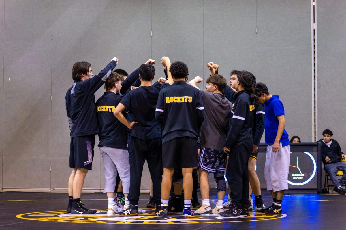 The varsity team huddle up together before starting the meet.