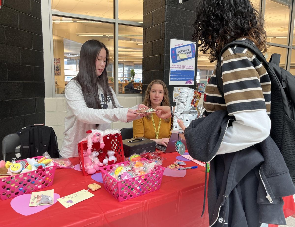 Selling Valentine's trinkets, junior Yi-Chen Kong and English composition assistant Stephanie Toledo manage sales of monkey plushies and googly-eyed keychains for the Peer Writing Center.
