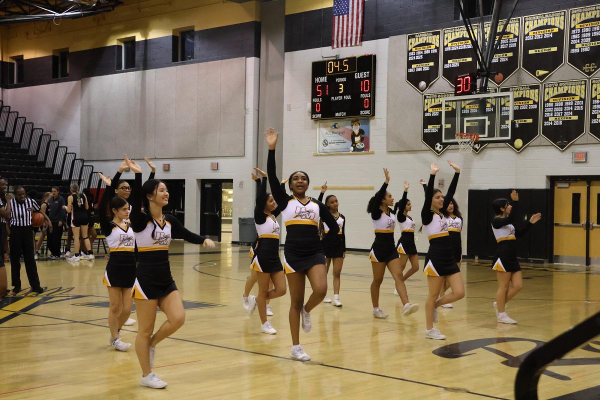 The winter cheer team waves to the crowd after performing a cheer during a timeout.