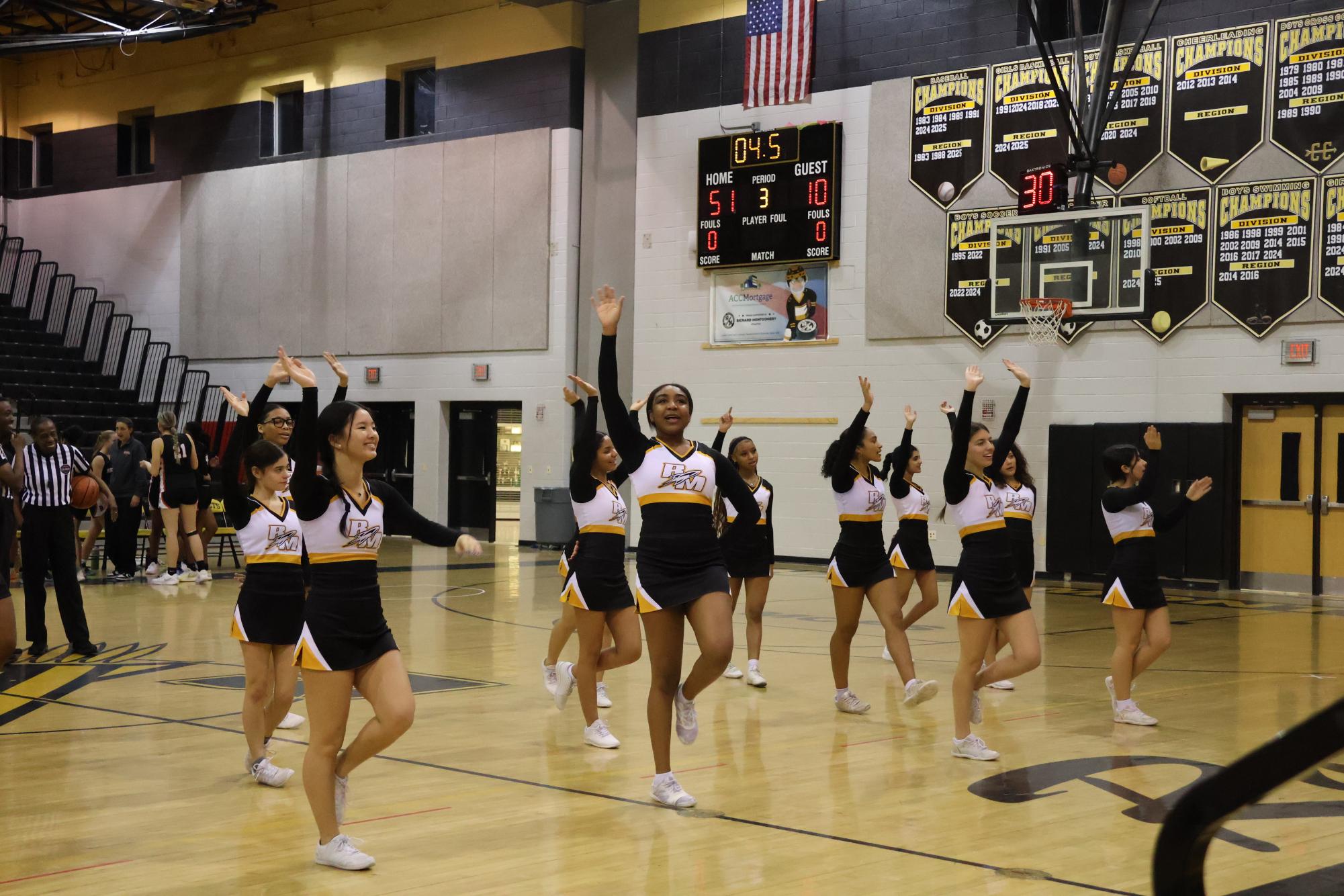 The winter cheer team waves to the crowd after performing a cheer during a timeout.