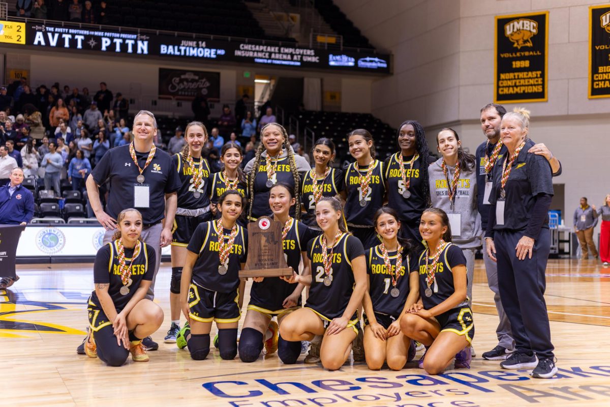 The Rockets pose on the UMBC basketball court with their State Finalist trophy after the game.