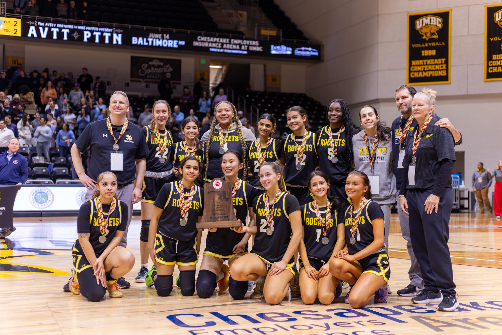 The Rockets pose on the UMBC basketball court with their State Finalist trophy after the game.