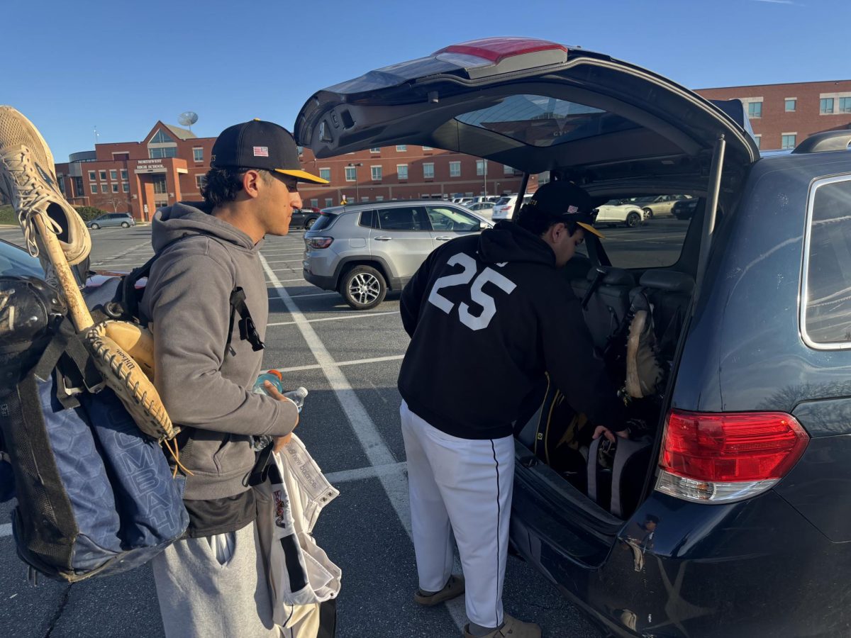 Senior Donovan Ford unloads his baseball bag from his car before the team's away scrimmage at Northwest.