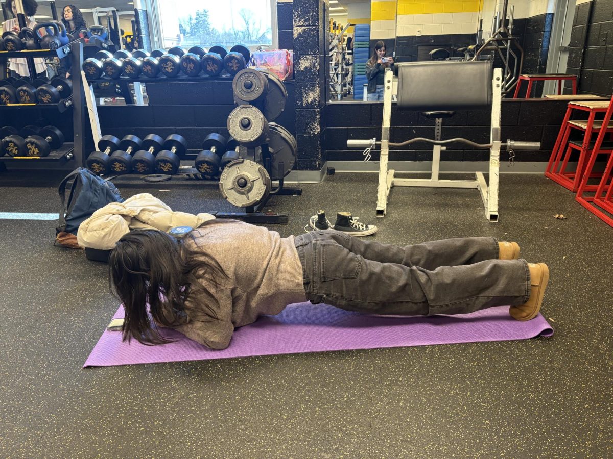 Timing her plank, senior Sophia Li pushes herself to succeed during her Girl's Weight Lifting class. 