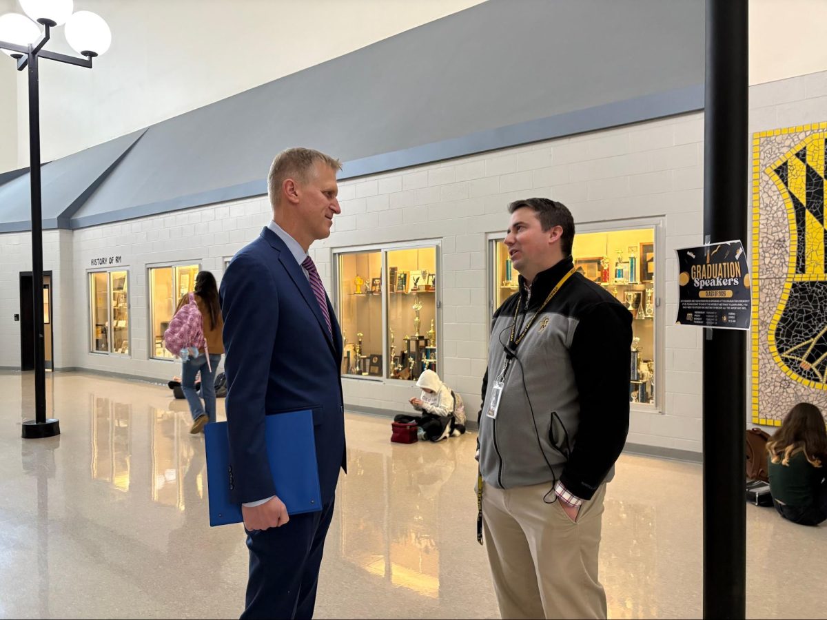 Magnet coordinator Joseph Jelen speaks to social studies teacher Jonathan Taylor in the hallway.