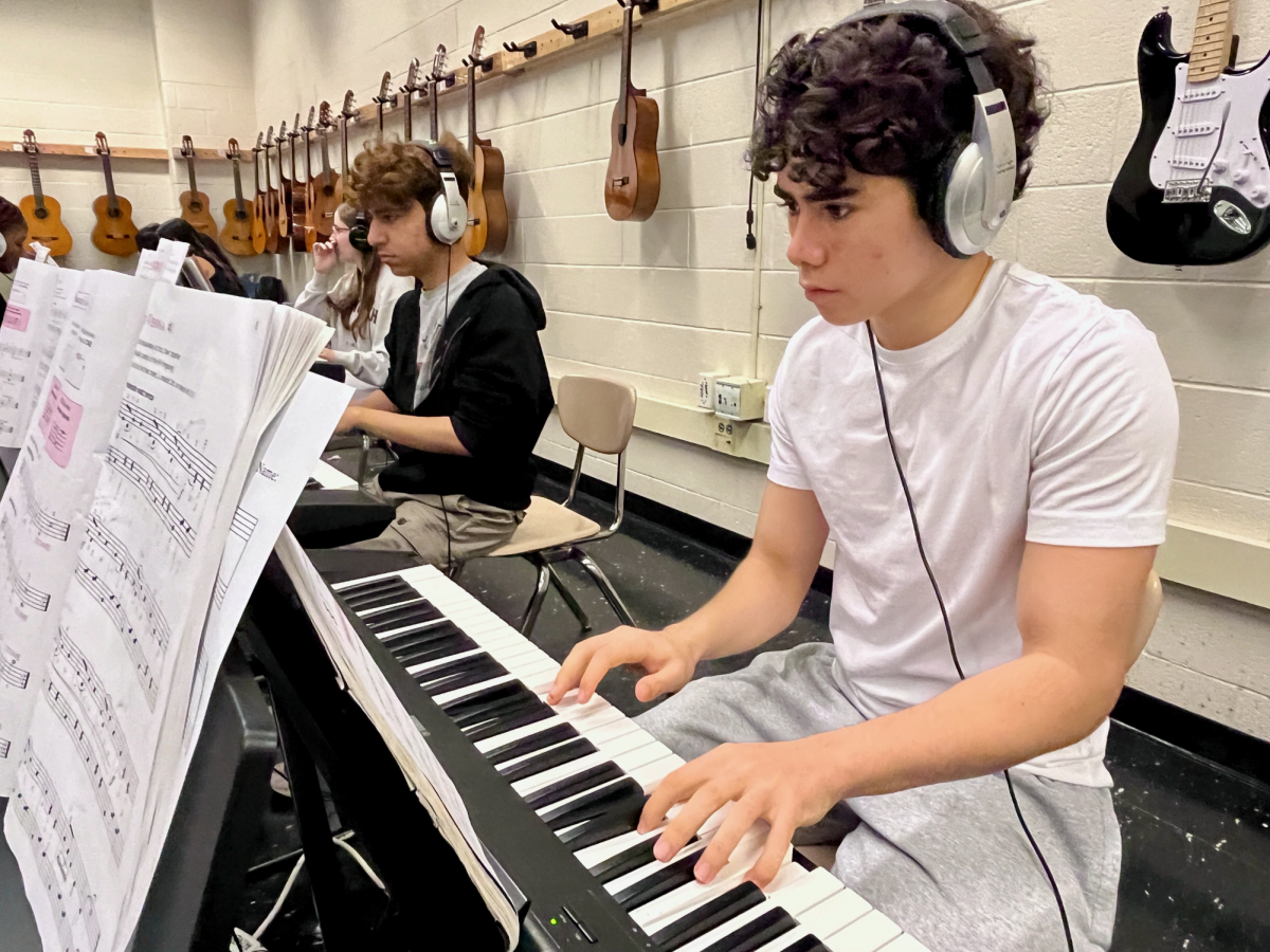 FINGERING THE KEYS, junior Michael Amster practices the piece “Laura.” Amster, who is a student in Piano 1, finds “Laura” to be quite challenging. While he started piano lessons at a young age, this year is his first back after a four-year hiatus. He says the most difficult part of playing the piece is keeping track of the many accidentals. “Laura” is actually more advanced than “Rocket Away,”—the assigned piece for the week’s recording assignment and where most of the class is at—but Mr. Koons allows his students to choose the pieces they want to spend class time practicing. “I like having this freedom,” Amster said. “I still did practice for the playing assignment tomorrow, but at the same time, because of my previous experience, I can challenge myself and practice what I want.” 