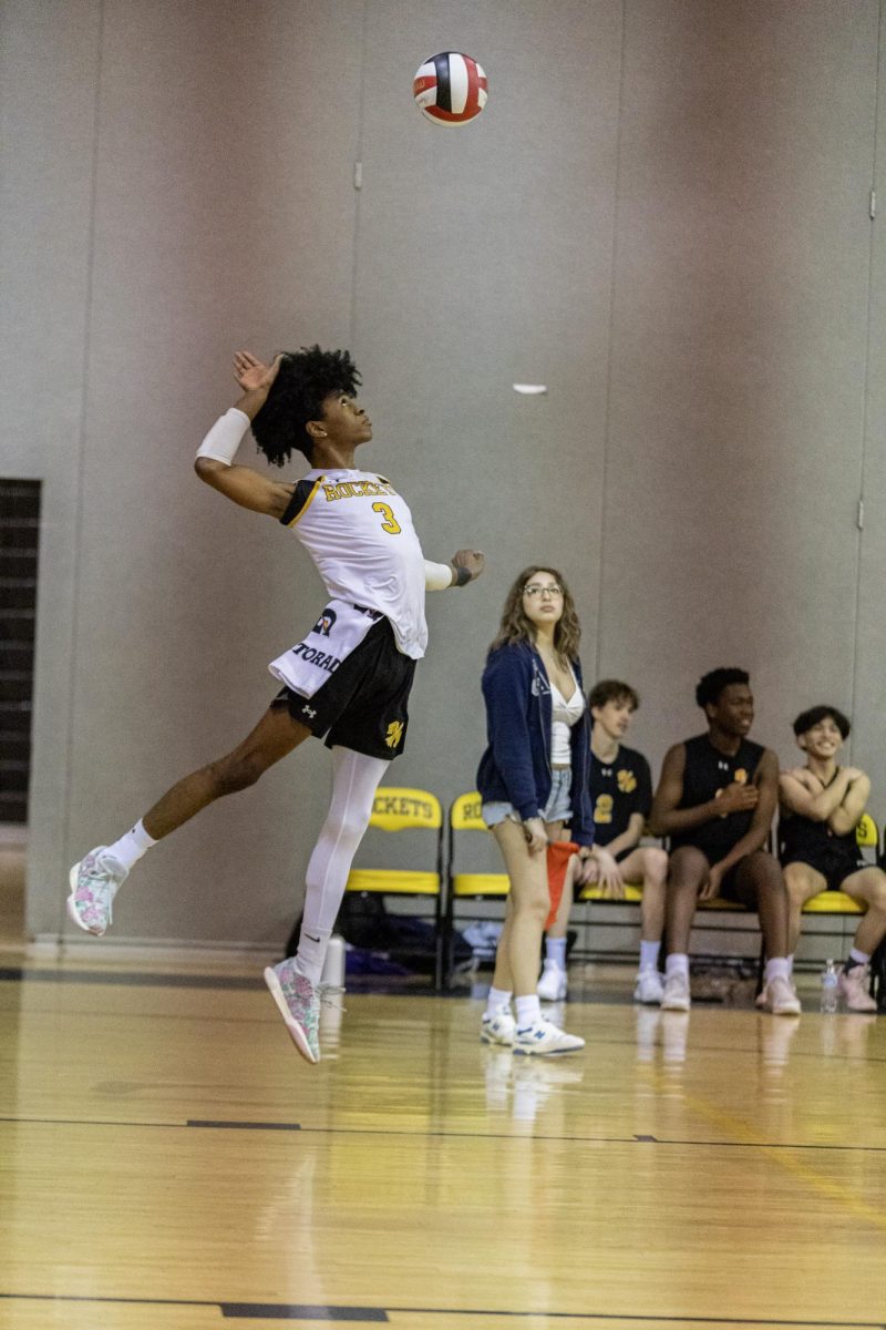 Number three serves the ball over the net during a match. 